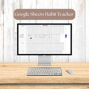 May include: A computer monitor displaying a Google Sheets Habit Tracker spreadsheet. The spreadsheet is a grid with rows for each day of the month and columns for different habits. The user can check off boxes to indicate that they have completed a habit for the day. The spreadsheet is on a wooden desk with a keyboard and mouse.