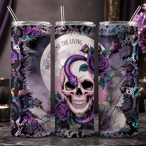 Peut inclure: Un gobelet cylindrique avec une paille en métal orné d'un crâne rose entouré d'un serpent violet et de roses violettes. Le motif présente un imprimé peau de serpent noir et violet avec le texte NEVER TRUST THE LIVING en arc de cercle.