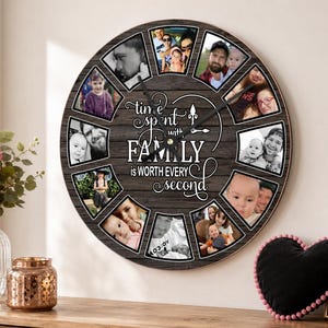 Op de afbeelding: Een ronde wandklok met een donkere houtnerfachtergrond en twaalf trapeziumvormige fotolijsten rondom de rand. In het midden staat de witte tekst: time spent with FAMILY is WORTH EVERY second. Zwarte wijzers bevinden zich in het midden.