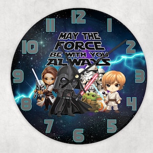 Op de afbeelding: Een ronde klok met een zwarte achtergrond en een galaxy-ontwerp. De wijzerplaat heeft een witte rand met zwarte Romeinse cijfers voor de uren. De wijzerplaat heeft ook een witte tekst die "Moge de kracht met je zijn, altijd" luidt. De wijzerplaat toont een groep cartoonfiguren uit Star Wars, waaronder Darth Vader, Yoda en Prinses Leia.