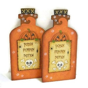 May include: Two orange and brown wooden pumpkin potion bottles with a skull and crossbones and the text "Poison Pumpkin Potion".