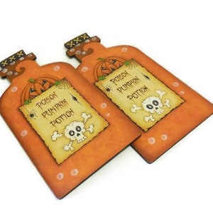 May include: Two orange and brown wooden bottle-shaped signs with a skull and crossbones and the text "Poison Pumpkin Potion".