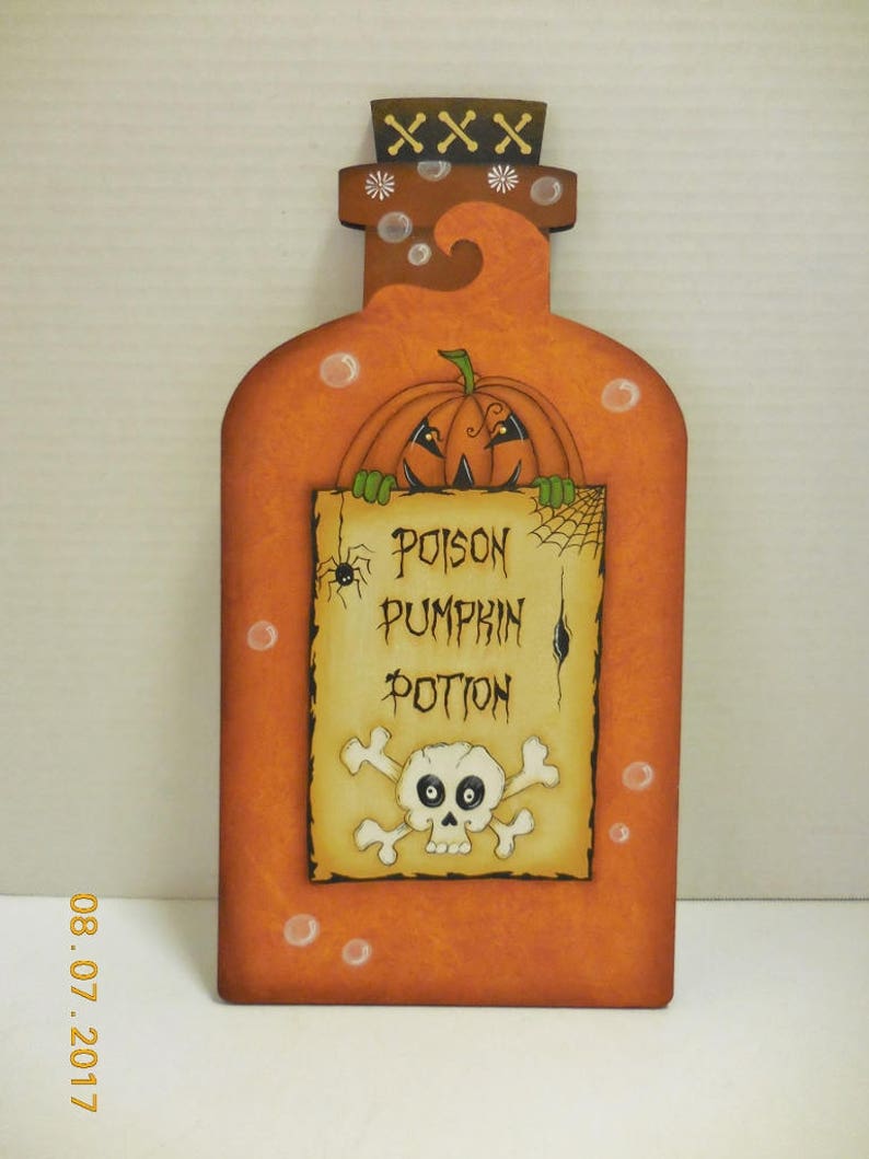 May include: Orange wooden bottle with a pumpkin face peeking out of the top. The bottle has a label that says "Poison Pumpkin Potion" with a skull and crossbones.