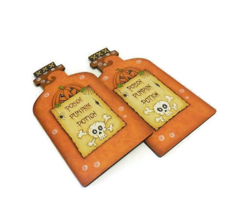 May include: Two orange and brown wooden bottle-shaped signs with a skull and crossbones and the text "Poison Pumpkin Potion".