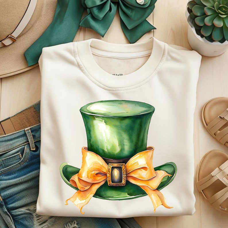 Puede incluir: Una sudadera blanca con un sombrero verde de duende con un lazo naranja sobre un fondo blanco.