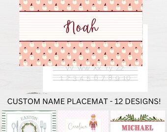 May include: A rectangular placemat featuring a repeating pattern of Santa Claus faces on a light pink background with a central white striped band displaying the name Noah in dark red script, alongside a practice sheet with letters and numbers.