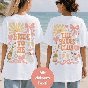 Puede incluir: Dos camisetas blancas con gráficos coloridos en la espalda. La izquierda muestra un sol, lazo, botella de champán, anillo y velo con el texto BRIDE TO BE. La derecha muestra un sol, lazo, champán, bola de discoteca y corazón con THE BRIDES CLUB.