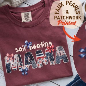 Może przedstawiać: Bordowa koszulka Comfort Colors z napisem "sail boating MAMA" w patchworkowym wzorze. Litery zdobione są motywami marynistycznymi, kokardkami i sztucznymi perłami. Koszulka ma okrągły dekolt i krótkie rękawy.
