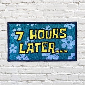 Peut inclure: Un écusson rectangulaire avec le texte "7 HOURS LATER..." en jaune, bordé de noir. Le fond est turquoise avec des motifs floraux bleu clair. Il a une bordure bleu foncé.