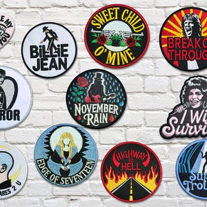 Può includere: Una collezione di toppe ricamate con vari disegni e testo. I disegni includono titoli di canzoni come "Sweet Child O' Mine", "Billie Jean" e "Highway to Hell". Altre toppe presentano frasi come "Can't Take My Eyes Off You" e "I Will Survive".