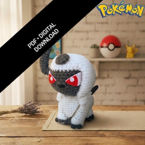 Pode incluir: Uma figura de Absol Pokémon de crochê, com corpo branco, rosto cinza escuro e olhos vermelhos. A figura é exibida em uma superfície de madeira com um tapete de cor neutra. A imagem também inclui o logotipo Pokémon e o texto "PDF • DOWNLOAD DIGITAL."
