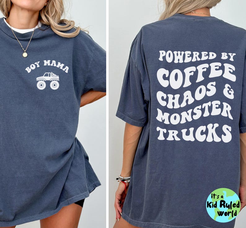 May include: Dark blue t-shirt with white text and graphic. The front of the shirt says "BOY MAMA" with a monster truck graphic. The back says "POWERED BY COFFEE CHAOS & MONSTER TRUCKS".