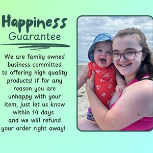May include: A person and a baby smiling on a beach. The baby wears a red onesie and a blue hat. The person wears glasses and a pink top. Text on the left reads "Happiness Guarantee" and a refund promise within 14 days.
