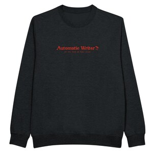 May include: A dark heather grey long-sleeve sweatshirt with the text "Automatic Writer" in red, followed by a small red bird graphic and the text "In the dark we feel alive" in smaller red text.