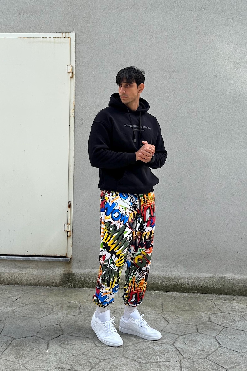 K&ouml;nnte beinhalten: Eine Person tr&auml;gt einen schwarzen Hoodie mit dem Text "making mistakes is common but making the same mistake twice is a choice" und eine bunte Hose mit grafischem Druck. Die Person tr&auml;gt wei&szlig;e Sneaker.