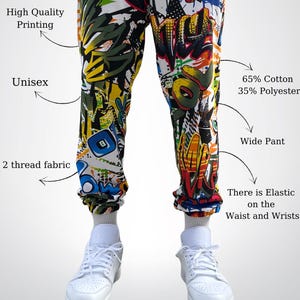 K&ouml;nnte beinhalten: Eine Jogginghose mit einem bunten Graffiti-Druck. Die Hose besteht aus 65% Baumwolle und 35% Polyester. Sie hat einen elastischen Bund und B&uuml;ndchen. Die Hose ist unisex und hat eine weite Beinweite.