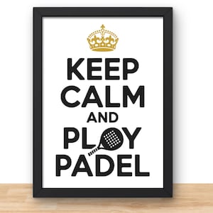 May include: A framed print with the words "KEEP CALM AND PLAY PADEL" in bold black letters. A gold crown is at the top, and a black padel racket graphic replaces the "O" in "PLAY". The frame is black.