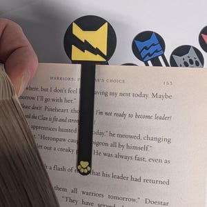 Thunder Clan keeping my place! This is one way of using the bookmark. You can also use it in a more traditional style and let the weight of the book being closed hold your bookmark in place.