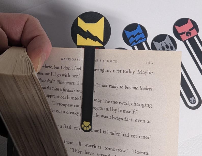 Thunder Clan keeping my place! This is one way of using the bookmark. You can also use it in a more traditional style and let the weight of the book being closed hold your bookmark in place.