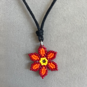 May include: A beaded flower pendant necklace with a black cord. The flower is red, orange, and yellow.