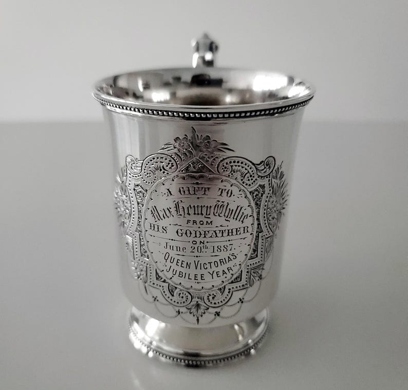 Puede incluir: Una copa de plata con una inscripci&oacute;n que dice "A Gift To Mar Henry @hullie From His Godfather On June 20th 1887. Queen Victoria's Jubilee Year."