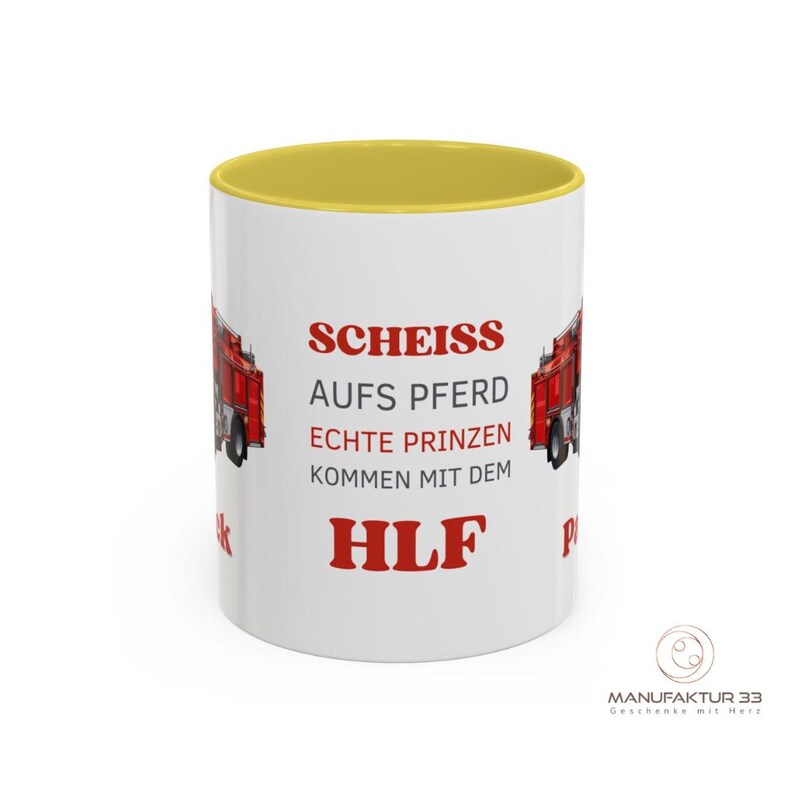 May include: White ceramic mug with a yellow interior and a red fire truck graphic. The mug features red text that reads "SCHEISS AUFS PFERD ECHTE PRINZEN KOMMEN MIT DEM HLF".