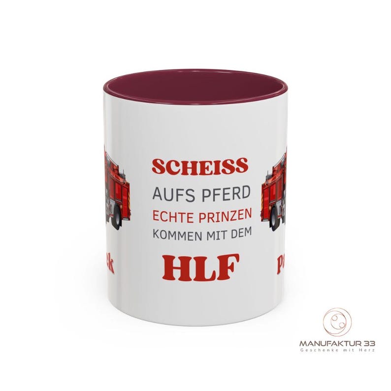 May include: White ceramic mug with a burgundy interior and a red fire truck graphic. The mug features red text that reads "SCHEISS AUFS PFERD ECHTE PRINZEN KOMMEN MIT DEM HLF". A logo is visible on the bottom right.