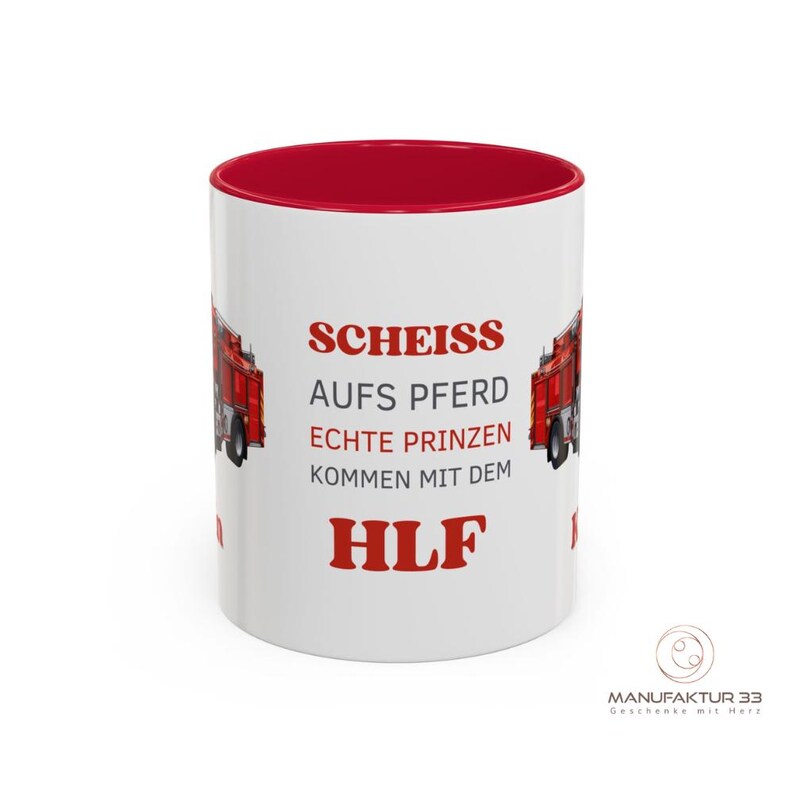 May include: White ceramic mug with a red interior and a red fire truck graphic. The mug features the text "SCHEISS AUFS PFERD ECHTE PRINZEN KOMMEN MIT DEM HLF" in red. The mug has a glossy finish.