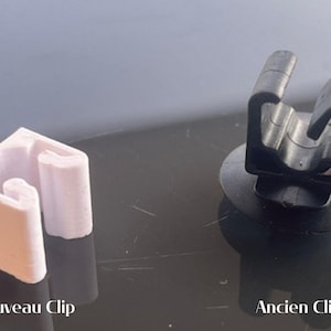 Peut inclure: Deux clips en plastique, l'un blanc et l'autre noir, sont présentés côte à côte. Le clip blanc est étiqueté "Nouveau Clip" et le clip noir est étiqueté "Ancien Clip".