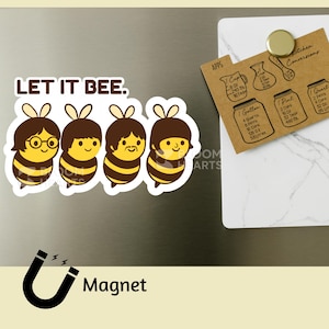 May include: A magnet with a design of four cartoon bees with brown hair and yellow and black striped bodies. The text "LET IT BEE" is displayed. A kitchen conversion chart is also visible. The magnet is on a metallic surface.