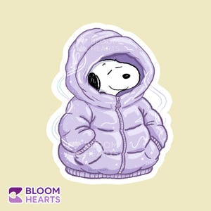 Puede incluir: Una pegatina de Snoopy de Peanuts, con una chaqueta acolchada lavanda con capucha. El personaje de dibujos animados sonríe con los ojos cerrados. La pegatina tiene un borde blanco y un fondo amarillo claro.