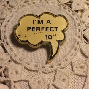 May include: A yellow plastic speech bubble with black trim reads "I'm a perfect 10".