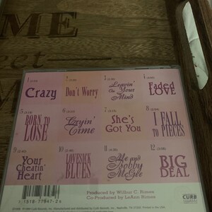 May include: A pink CD case with the title "Me and Bobby McGee" and a list of 12 songs with their titles and lengths. The songs include "Crazy", "Don't Worry", "Leavin' Your Mind", "Faded Love", "Born to Lose", "Cryin' Time", "She's Got You", "I Fall to Pieces", "Your Cheatin' Heart", "Lovesick Blues", "Me and Bobby McGee", and "Big Deal".