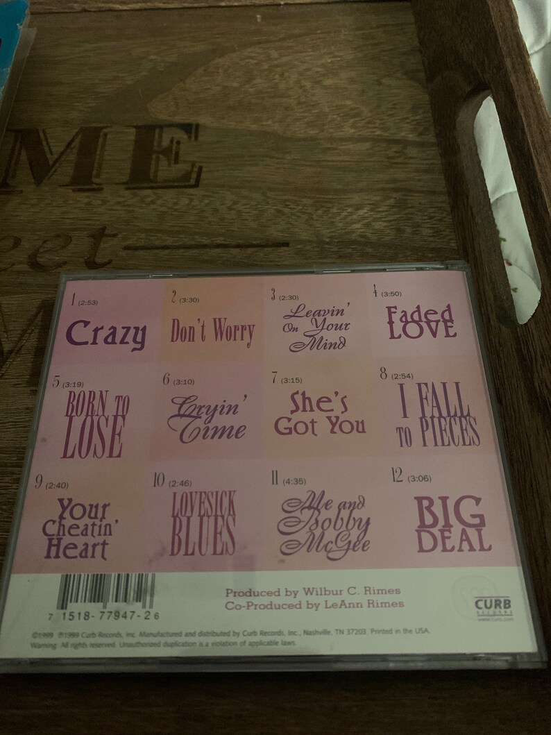 May include: A pink CD case with the title "Me and Bobby McGee" and a list of 12 songs with their titles and lengths. The songs include "Crazy", "Don't Worry", "Leavin' Your Mind", "Faded Love", "Born to Lose", "Cryin' Time", "She's Got You", "I Fall to Pieces", "Your Cheatin' Heart", "Lovesick Blues", "Me and Bobby McGee", and "Big Deal".