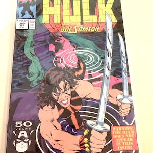 Könnte beinhalten: Ein Comic-Cover mit dem unglaublichen Hulk, mit dem Text "The Incredible Hulk" und "Featuring: Doc Samson" in großen, fetten Buchstaben. Die Cover-Illustration zeigt eine Frau mit braunen Haaren und einem rot-braunen Kostüm, die zwei Schwerter hält. Der Text "Warning: The Hulk does not appear in this issue!" befindet sich in einem gelben Kasten unten rechts.