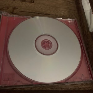 May include: A blank CD in a red jewel case. The CD is in a wooden tray.