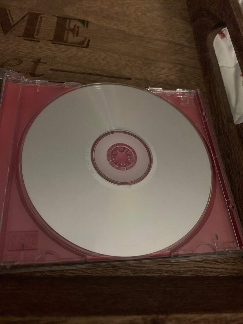 May include: A blank CD in a red jewel case. The CD is in a wooden tray.