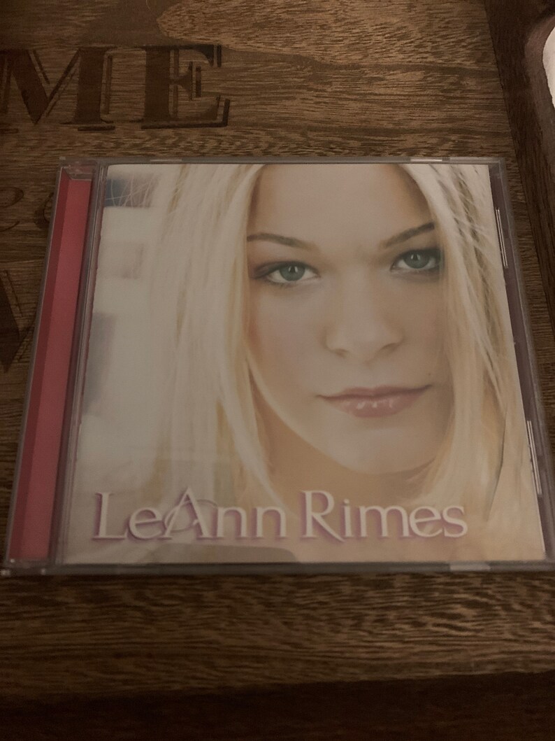 May include: A CD case with a photo of LeAnn Rimes on the front. The case is clear plastic with a red spine. The photo shows LeAnn Rimes with blonde hair and a light background.