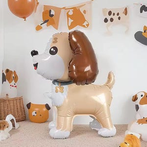 May include: A large, inflatable dog balloon in tan, brown, and white, with a smiling face and a small collar. The balloon is part of a dog-themed party decoration set, with other dog-shaped balloons and banners visible.