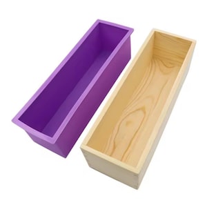 Può includere: Due stampi per sapone rettangolari. Uno è in silicone viola vibrante, l'altro è una scatola di legno naturale. Entrambi sono vuoti e pronti per l'uso. Lo stampo in legno mostra la venatura naturale del legno.