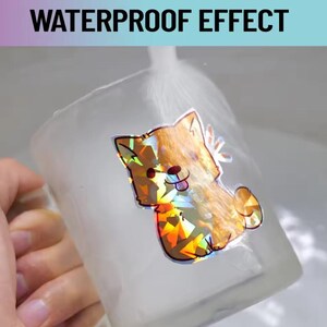 May include: A clear glass with a holographic sticker of a cartoon dog. The sticker has a colorful, iridescent effect. The text "WATERPROOF EFFECT" is at the top of the image.