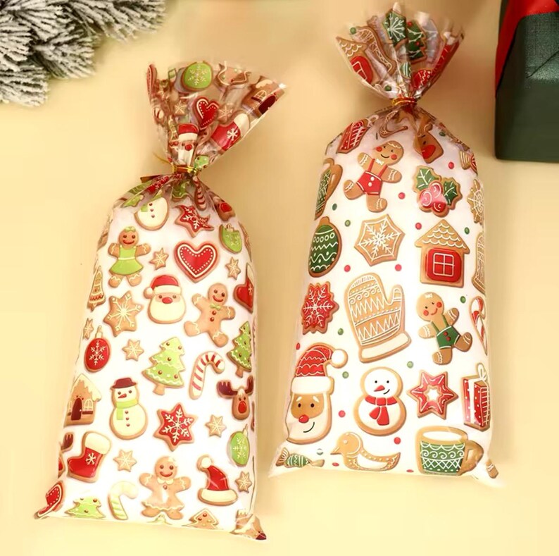 Puede incluir: Dos bolsas de regalo transparentes de celof&aacute;n llenas de galletas navide&ntilde;as. Las bolsas est&aacute;n decoradas con varias galletas de jengibre, Pap&aacute; Noel y dise&ntilde;os de &aacute;rboles de Navidad. Las bolsas est&aacute;n atadas en la parte superior con lazos dorados.