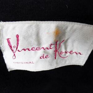 May include: A white label with pink embroidery that reads "Vincent de Koven ORIGINAL".