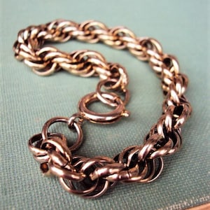 May include: A gold-toned chain bracelet with a twisted rope design. The bracelet has a lobster claw clasp.