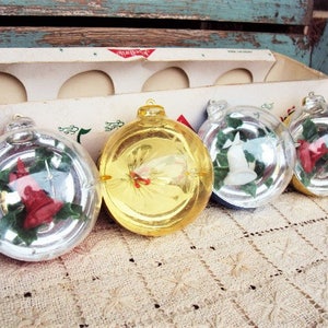 May include: Four vintage Christmas ornaments in a box. The ornaments are clear glass with a silver, gold, and white design. The ornaments are decorated with holly leaves, berries, and a bell.