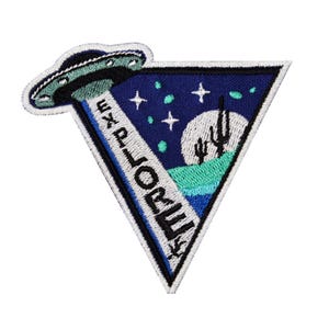 May include: An embroidered patch with a triangle shape. The patch features a UFO, a crescent moon, and a desert landscape with cacti. The text "EXPLORE" is written vertically on the patch.
