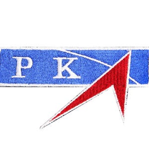 Op de afbeelding: Een geborduurde patch in blauw en rood met de letters "PK" in wit. De patch heeft een rode pijl die naar rechts wijst.