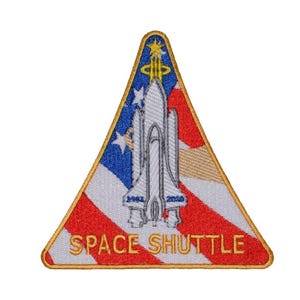 May include: An embroidered patch in the shape of a triangle, featuring a white space shuttle against a red, white and blue American flag background. The text "SPACE SHUTTLE" is embroidered in white on the patch.