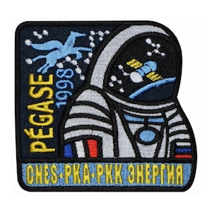 Puede incluir: Un parche bordado azul y amarillo con un astronauta blanco en un traje espacial. El parche tiene el texto "PEGASE 1998" y "CNES-PKA-RKK ENERGIA" en amarillo.