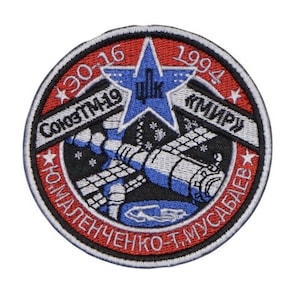 May include: A red, white and blue embroidered patch with a star and the text "СоюзТМ-19 ДПК «МИР» * ЮМАЛЕНЧЕНКО-Т. МУСАБАЕВ" and the numbers "30-16" and "1994".